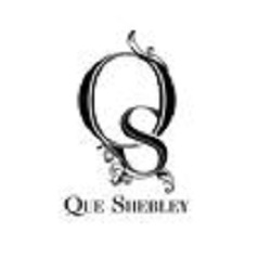 Que Shebley Logo